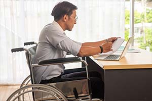 Homme en fauteuil travaillant, représentant la politique inclusive